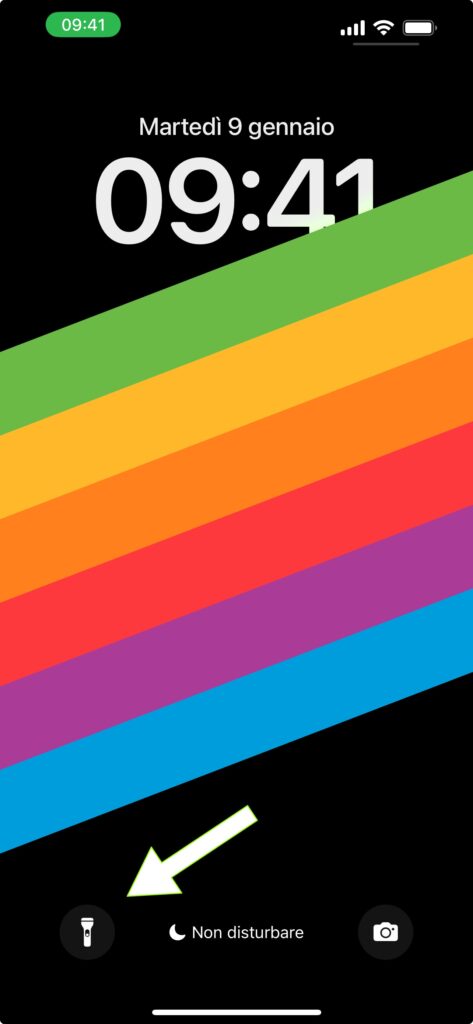 Schermata di blocco dell'iPhone dove una freccia bianca indica il pulsante con il quale accendere la torcia dell'iPhone