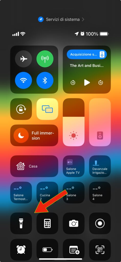 Schermata del centro di controllo dell'iPhone con una freccia rossa che indica il pulsante con il quale accendere la torcia dell'iPhone
